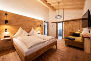 a bedroom with a large bed in a room with wooden walls at Die Zwei Sonnen Chalets in Ofterschwang