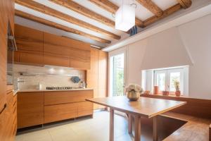 una cucina con armadi in legno e tavolo in legno di Luxury Garden Mansion R&R a Venezia