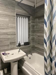 bagno con lavandino e vasca di Cosy 3 Bedroom house, Free parking & WIFI a Nottingham