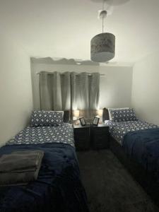 um quarto com 2 camas e uma janela com cortinas em Cosy 3 Bedroom house, Free parking & WIFI em Nottingham