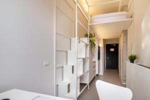 a room with white shelving and a hallway at Camplus San Pietro in Rome