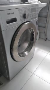 a washing machine sitting on a white floor at Apartamento Moderno Poços de Caldas in Poços de Caldas +6 photos