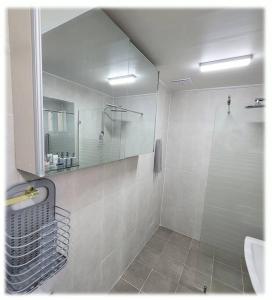 y baño con ducha, lavabo y espejo. en House that only walks on flowery paths, en Wonju