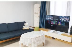 sala de estar con sofá azul y TV en House that only walks on flowery paths, en Wonju