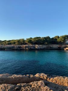 a view of a body of water with rocks at Villas Serena in Cala Blanca