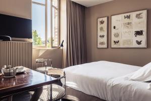 a hotel room with a bed and a table at Villa Mirasol in Mont-de-Marsan