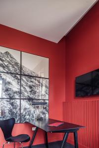 a dining room with red walls and a black table and chairs at Villa Mirasol in Mont-de-Marsan