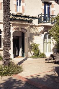 a building with a door and a tree and a bench at Villa Mirasol in Mont-de-Marsan