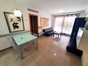 - un salon avec une table et un canapé dans l'établissement Patacona Resort Apartments Primera Linea, à Valence