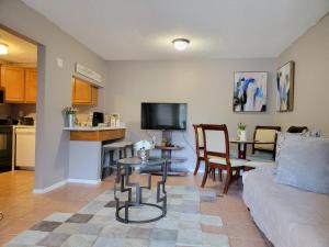 Comfy & Convenient 1BR Apartment Near Oaks Mall & Medical Center Fast WIFI في غاينيسفيل: غرفة معيشة مع أريكة وطاولة