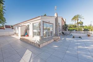 a house with a large patio with chairs at Casa Abuelita in Torrevieja