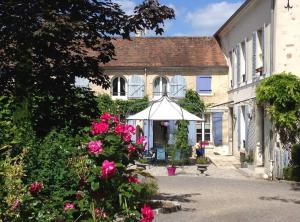 a white umbrella in front of a house with roses at LA CHASSE ROYALE in Plailly
