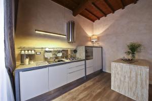 una cucina con armadi bianchi e piano cottura di Apartments Florence - Giglio santa trinita a Firenze