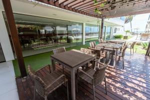 a group of tables and chairs on a patio at PÉ NA AREIA - 2 qt - 2 WC - PISCINA - wifi - garagem privativa in João Pessoa