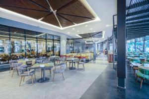 un comedor con mesas, sillas y ventanas en Calyptus Kirman Premium - Ultra All Inclusive, en Side