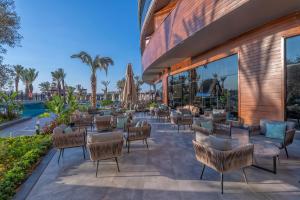 eine Terrasse mit Stühlen und Tischen im Resort in der Unterkunft Kirman Calyptus Resort & SPA in Side