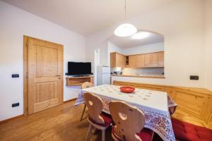 a kitchen and dining room with a table and chairs at La pratolina piano terra in Castello di Fiemme