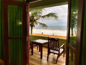 ヒッカドゥワにあるSerenade Beach Hotelのビーチの景色を望むバルコニー(テーブル付)
