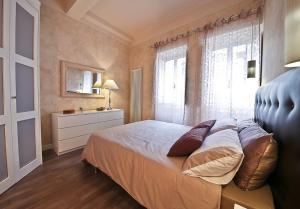 una camera da letto con un letto con cuscini e una finestra di Apartments Florence - Giglio santa trinita a Firenze Altre 16 foto