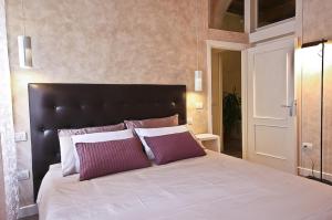 una camera da letto con un grande letto con cuscini viola e bianchi di Apartments Florence - Giglio santa trinita a Firenze