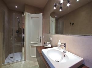 un bagno con lavandino, doccia e specchio di Apartments Florence - Giglio santa trinita a Firenze