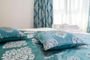 a bed with blue and white pillows on it at VILA SILFAR in Măcin