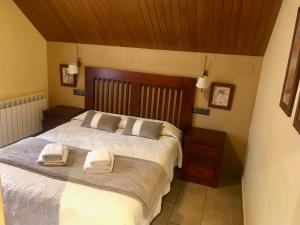 ein Schlafzimmer mit einem großen Bett mit zwei Handtüchern darauf in der Unterkunft Apartamentos Blasco in Tramacastilla de Tena