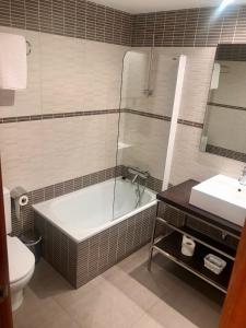 ein Badezimmer mit einer Badewanne, einem WC und einem Waschbecken in der Unterkunft Apartamentos Blasco in Tramacastilla de Tena
