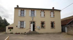 Una casa vieja con una cruz en la parte delantera. en La Chaussée de l'Etang, en Marcenay