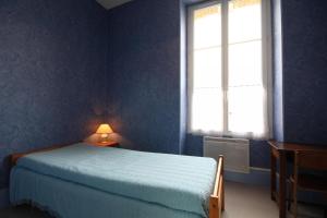 Dormitorio azul con cama y ventana en La Chaussée de l'Etang, en Marcenay