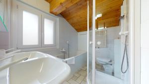 ein weißes Badezimmer mit Badewanne und Toilette in der Unterkunft 5min. from the ski slopes Crans-Montana, 2 bedrooms, covered parking in Crans-Montana + 19 Fotos