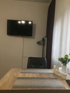 a room with a table with a television on the wall at REoN Apartment No 8, Osijek - self CHECK IN in Osijek