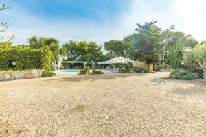 a large yard with a house and a swimming pool at Albergo Residenziale Menhirs in Putzu Idu