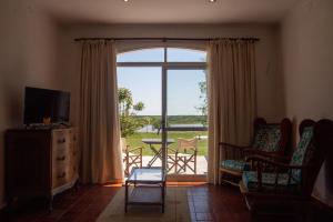 a living room with a large sliding glass door with a balcony at La Mansa Riverside in Esquina