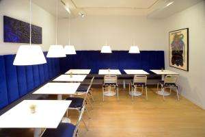 a conference room with tables and chairs and lights at Hotel Colombia in Trieste