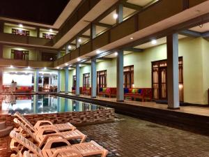a hotel with a pool with chairs and tables at Serenade Beach Hotel in Hikkaduwa