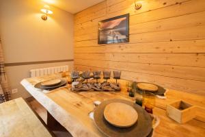 uma sala de jantar com uma mesa de madeira e copos de vinho em Résidence Les Esplaneilles em Formiguères
