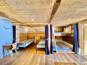 a room with two bunk beds and a table at Berglodge Ascharina in Sankt Antönien