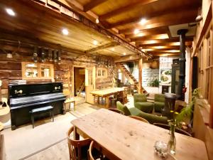 a living room with a piano and a table at Berglodge Ascharina in Sankt Antönien