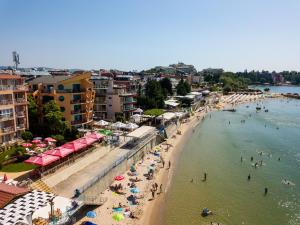 a beach with umbrellas and people in the water at Family Hotel Evridika in Nesebar