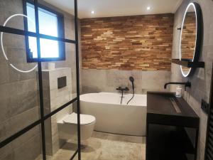 a bathroom with a tub and a toilet and a sink at DBO81 Spacious apartment in the center and beach nearby in Domburg