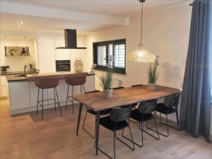 a kitchen and dining room with a wooden table and chairs at DBO81 Spacious apartment in the center and beach nearby in Domburg +8 photos