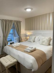 JT Abergwaun hotel في فيشجارد: سرير كبير عليه منشفتين