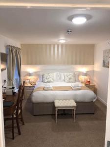 JT Abergwaun hotel في فيشجارد: غرفة نوم بسرير كبير وطاولة