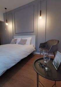 una camera da letto con un letto e un tavolo con occhiali di On the river Ultra central Suites a Bucarest