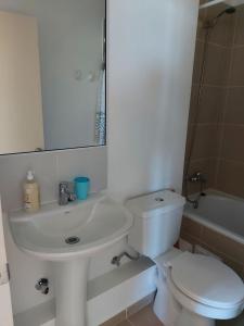cómodo y bello departamento en la serena في لا سيرينا: حمام ابيض مع مرحاض ومغسلة
