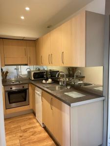 a kitchen with wooden cabinets and a sink and a stove at Alexandre in Nice