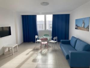 sala de estar con sofá azul y mesa en Apartamentos Tao Noah, en Puerto del Rosario
