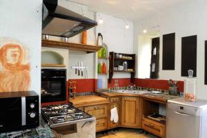 uma grande cozinha com armários de madeira e um fogão forno superior em Le Domaine du Crescent em Chezelles