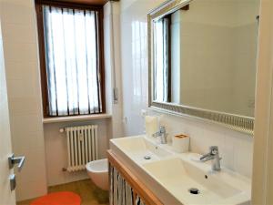een badkamer met een wastafel, een spiegel en een toilet bij Appartamento con 3 camere in centro Aosta CIR-AOSTA-0325 in Aosta